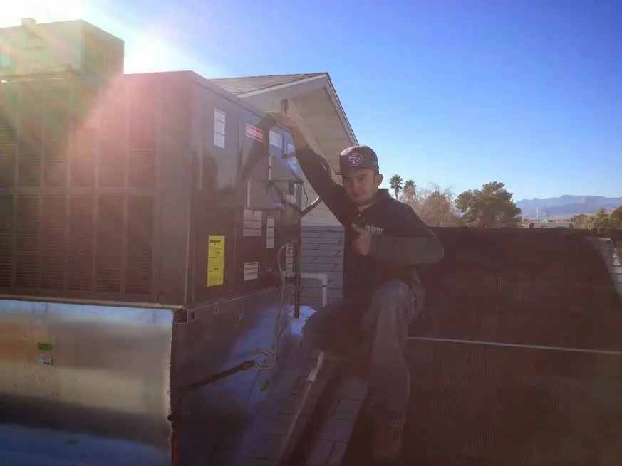 HVAC technician performing AC Tune-Up on a rooftop unit in East Lake-Orient Park